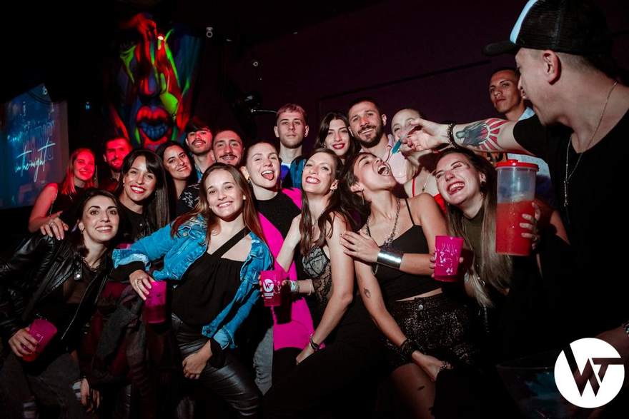 El grupo entero en el boliche, entre luces de neón